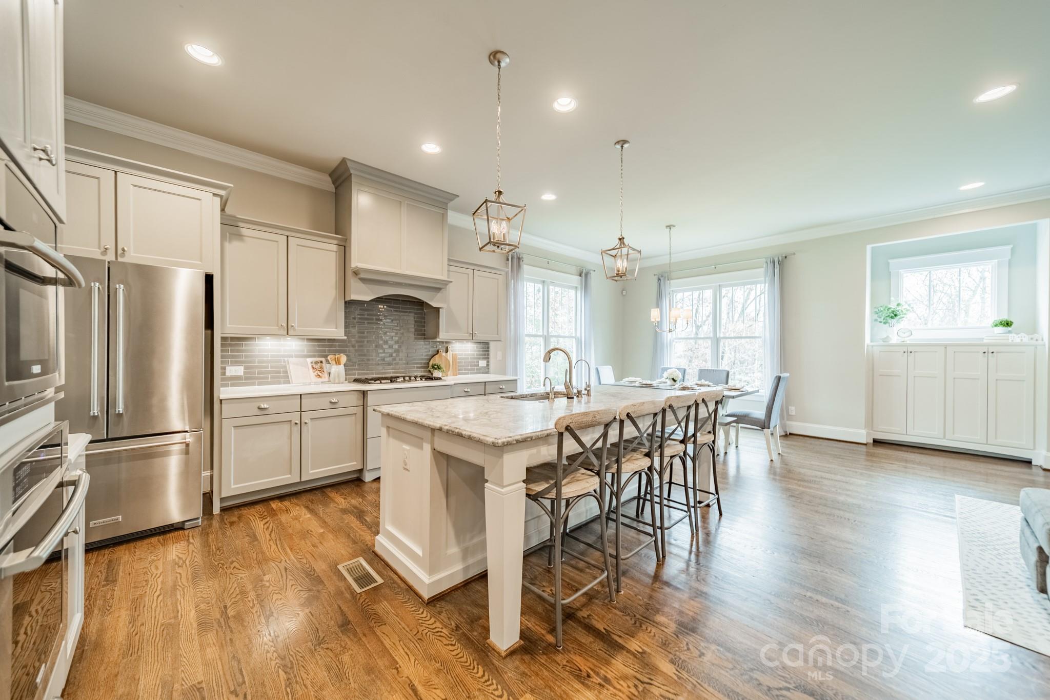 348 Meares Court Fort Mill, SC 29715 - Photo 11 of 47 a kitchen with stainless steel appliances granite countertop a refrigerator a sink dishwasher a stove and white cabinets with wooden floor