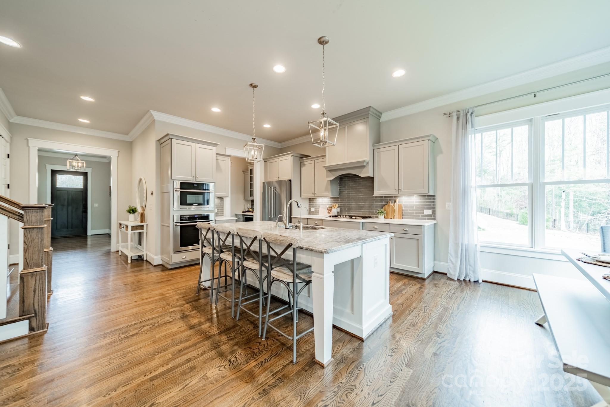 348 Meares Court Fort Mill, SC 29715 - Photo 13 of 47 a kitchen with stainless steel appliances kitchen island granite countertop a stove a sink a refrigerator and white cabinets with wooden floor