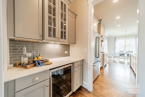 a kitchen with stainless steel appliances a refrigerator a sink a stove and white cabinets