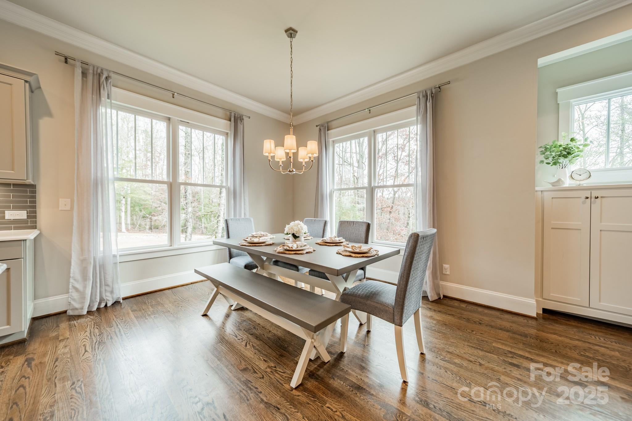 348 Meares Court Fort Mill, SC 29715 - Photo 15 of 47 a dining room with wooden floor a chandelier a glass table and chairs