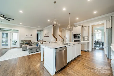 a large kitchen with stainless steel appliances kitchen island a large counter top and a wooden floors