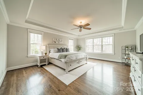 a bedroom with a large bed and a chandelier