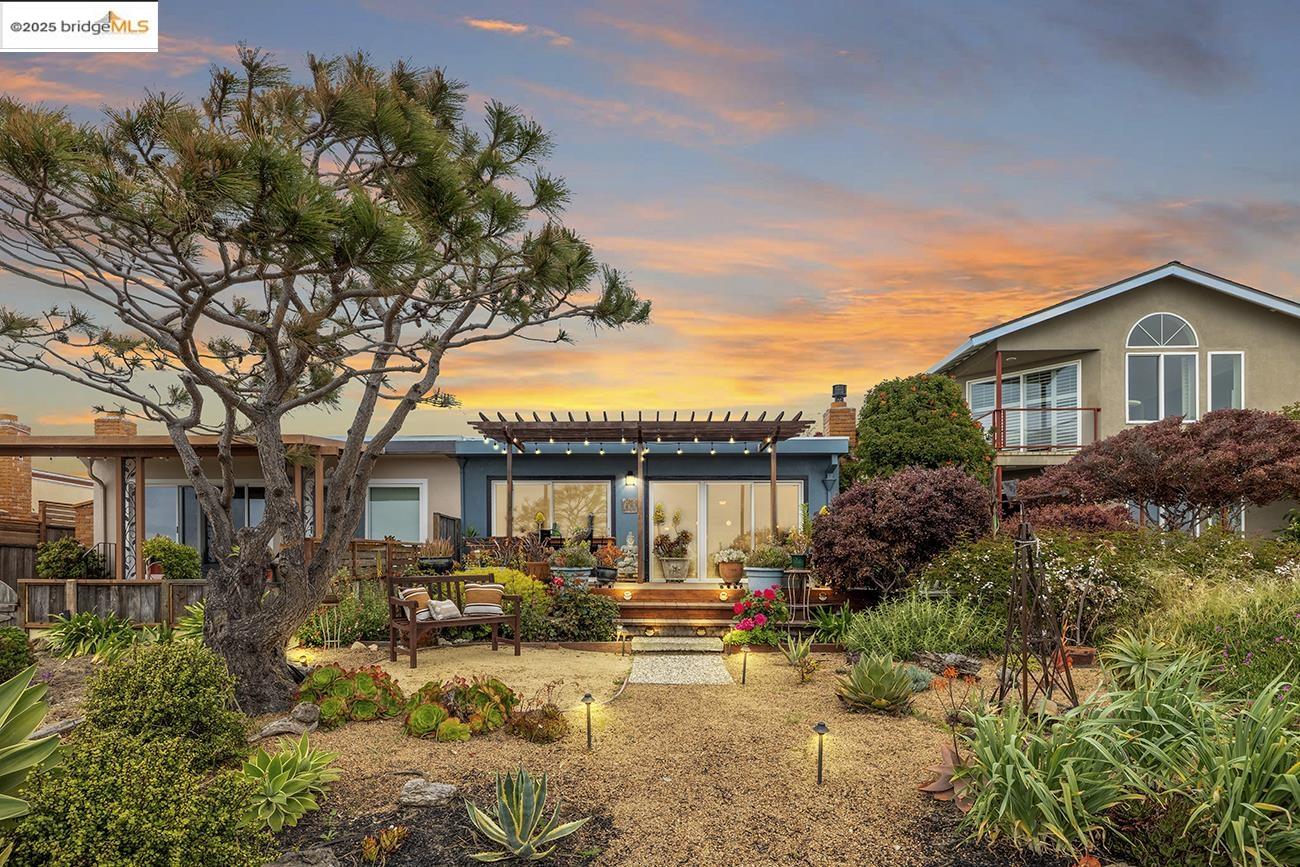 a view of a house with a tree in front of it