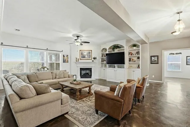 a living room with furniture a flat screen tv and a fireplace