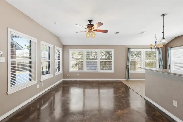 a view of a living room with a large window wooden floor and chandelier
