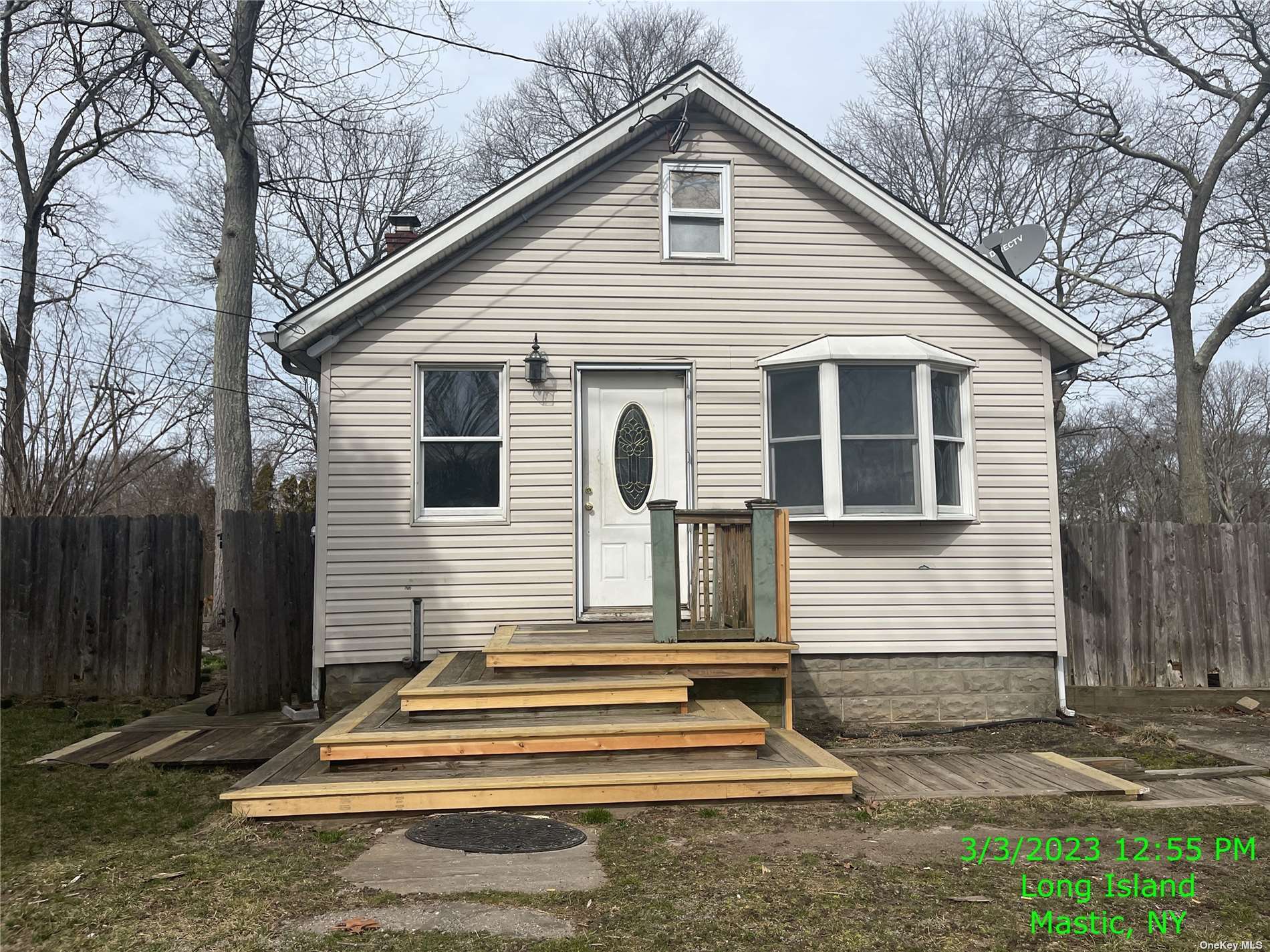 a view of a house with a yard and large tree