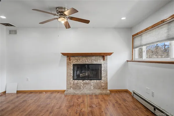 a living room with wooden floor and a fireplace