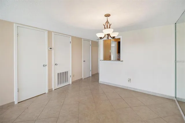 a view of a room with a chandelier fan and refrigerator