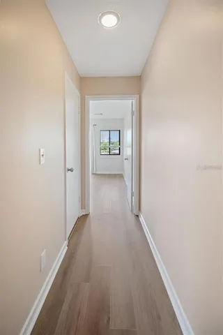 a view of a hallway with wooden floor and a window
