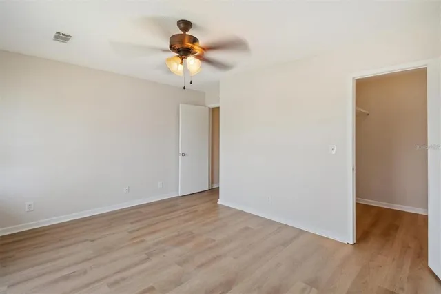a view of room with hardwood floor and ceiling fan