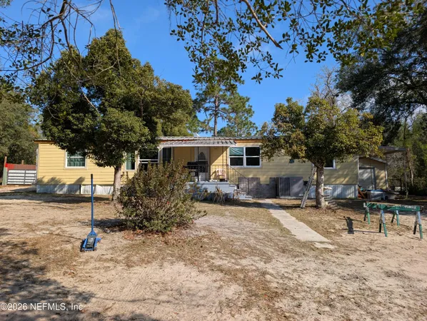 a view of a house with backyard and a tree
