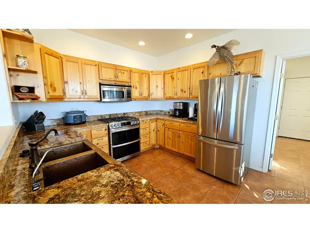 a kitchen with stainless steel appliances granite countertop a sink refrigerator and microwave