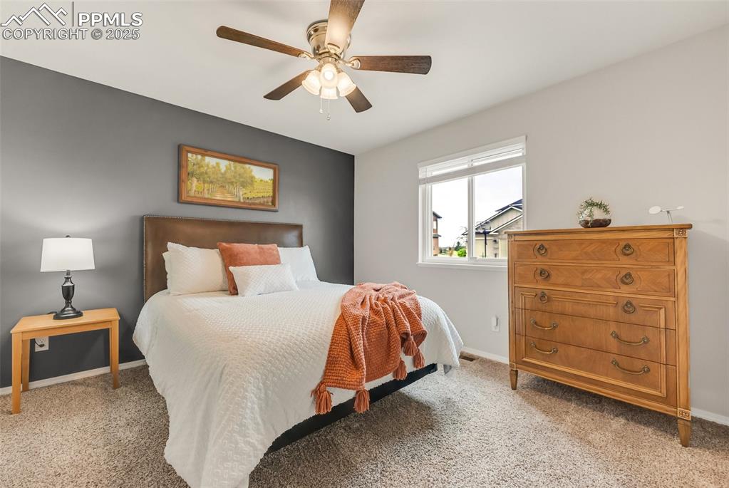 10467 Pictured Rocks Drive Peyton, CO 80831 - Photo 28 of 47 a bedroom with a bed and a chandelier