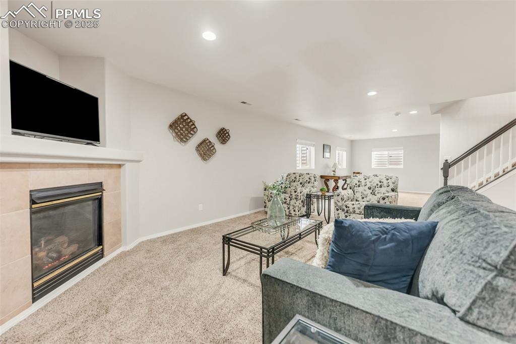 10467 Pictured Rocks Drive Peyton, CO 80831 - Photo 34 of 47 a living room with furniture a flat screen tv and a fireplace