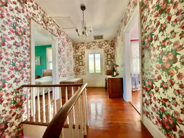 a view of a hallway with wooden floor and staircase