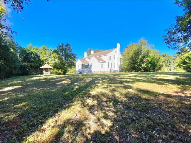 a view of a big yard with large trees