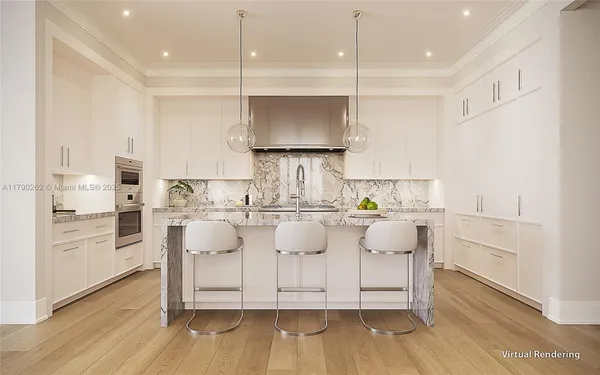 a room with kitchen island granite countertop a white cabinets and stainless steel appliances