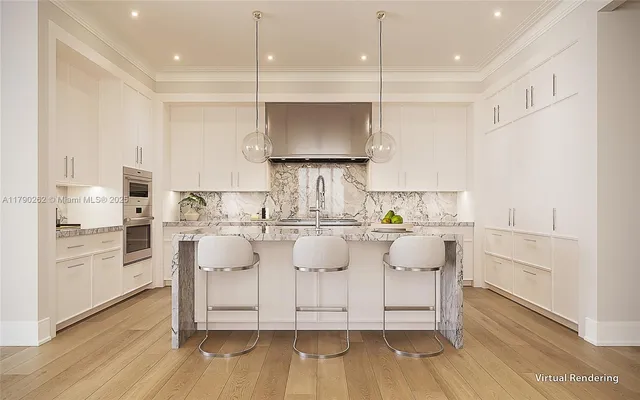a room with kitchen island granite countertop a white cabinets and stainless steel appliances