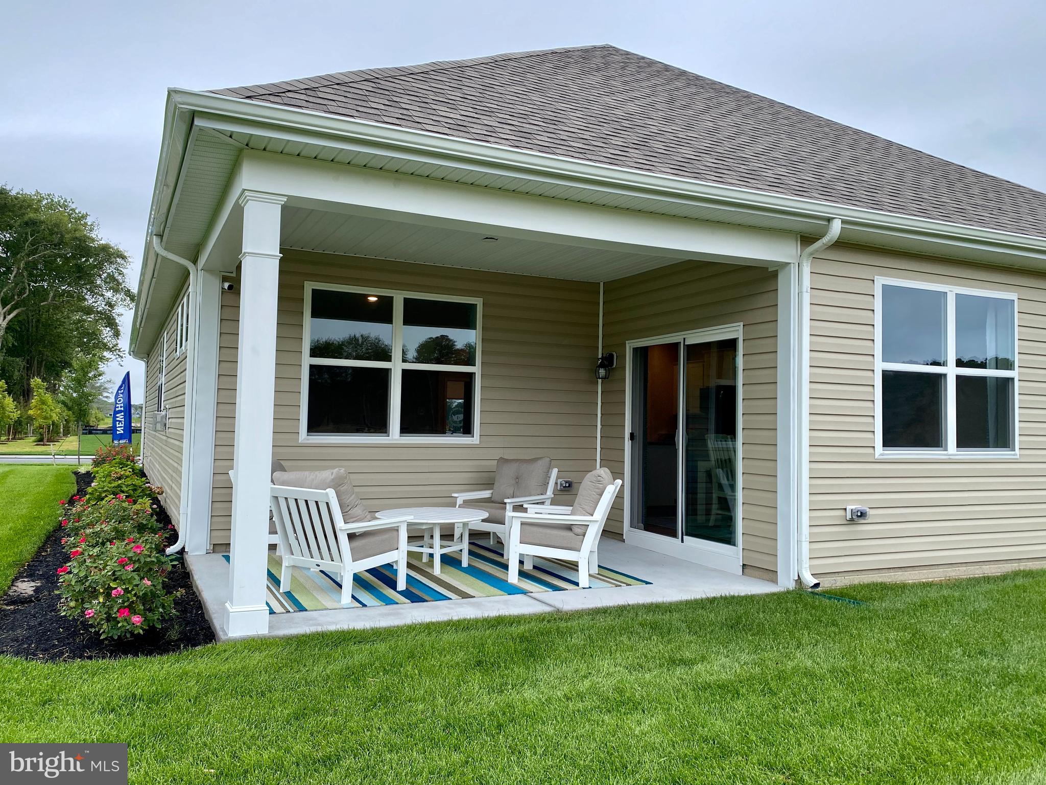 8740 Harper Way Easton, MD 21601 - Photo 23 of 26 a front view of a house with a yard table and chairs