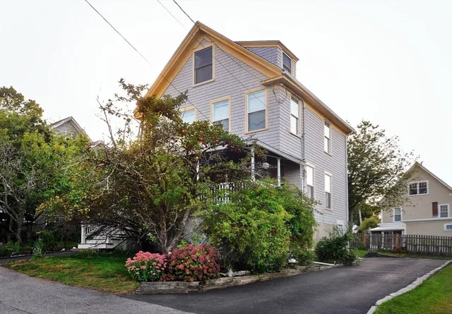 a front view of a house with a yard and a garden