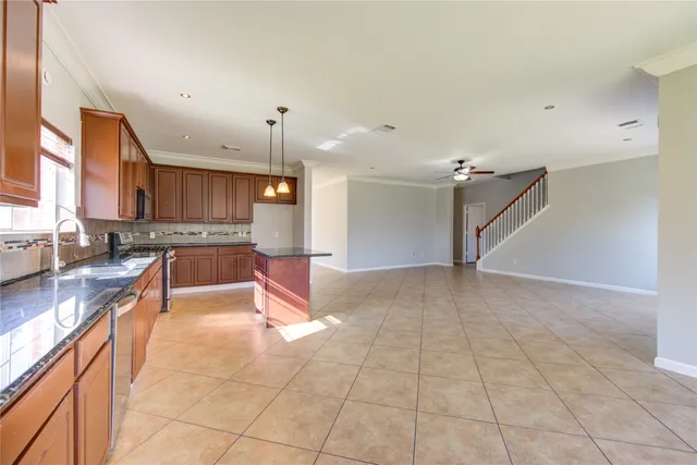 a large kitchen with granite countertop a large counter top space a sink and cabinets