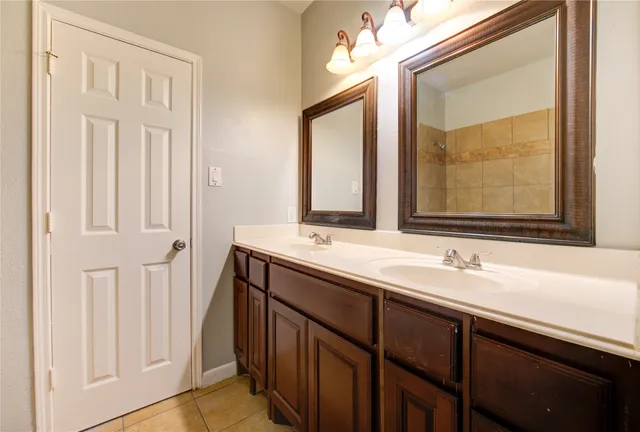 a bathroom with a double vanity sink and a mirror