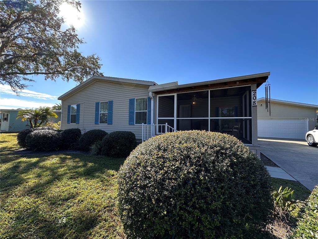 a front view of house with yard and trees in the background