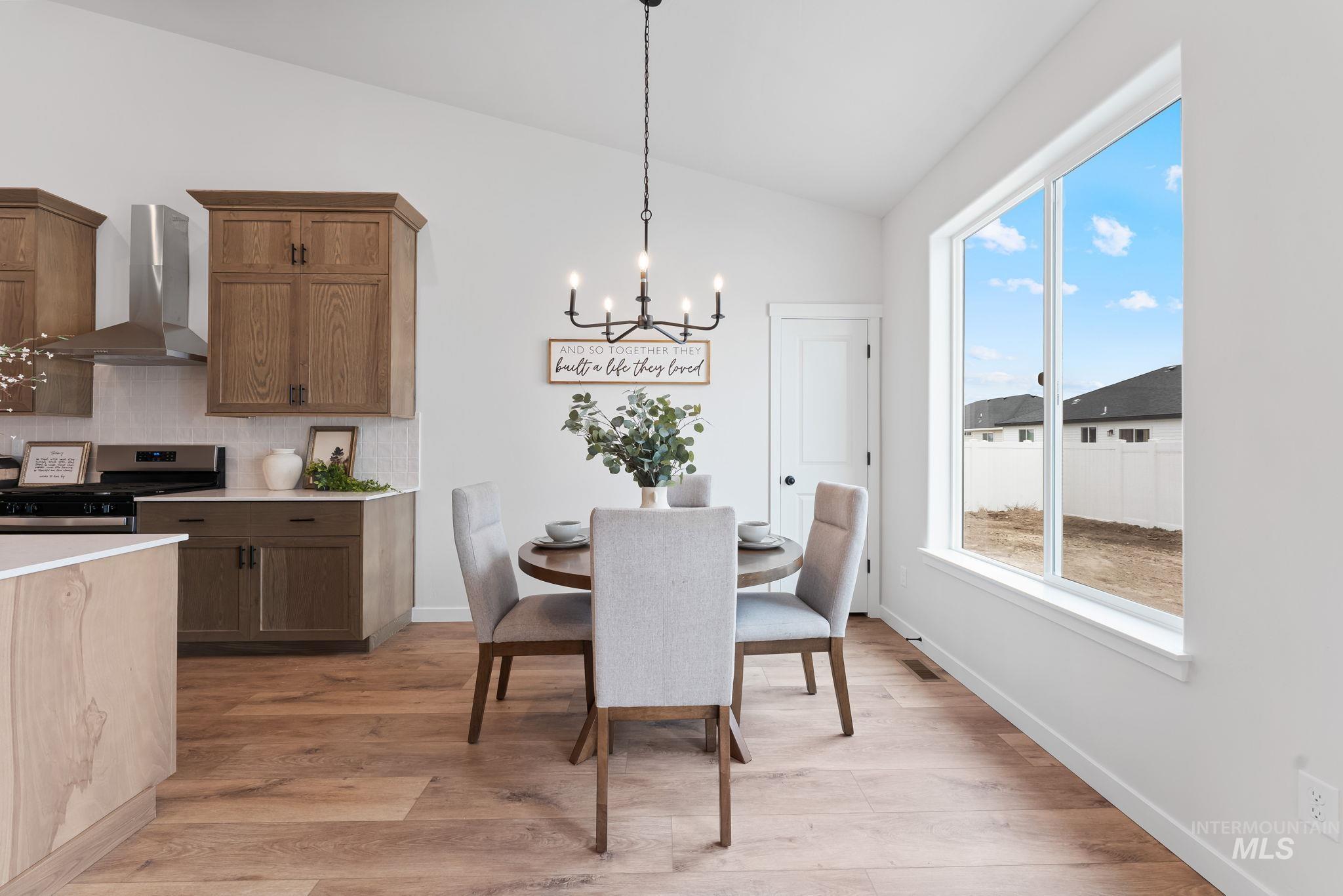 2220 Great Basin Way Burley, ID 83318 - Photo 14 of 39 Dining area with vaulted ceiling, suspended lighting, and light wood-style floors