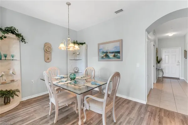 a view of a dining room with furniture a chandelier and wooden floor