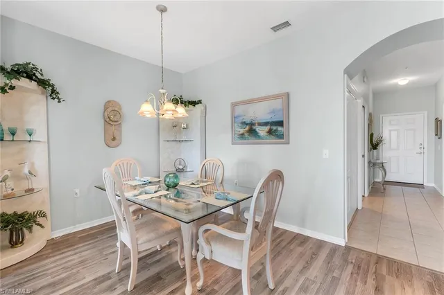a view of a dining room with furniture a chandelier and wooden floor