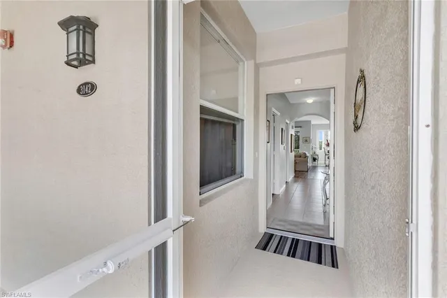 a view of a hallway with a livingroom and a bathroom with sink