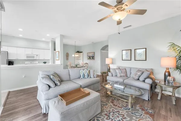 a living room with furniture and a view of kitchen