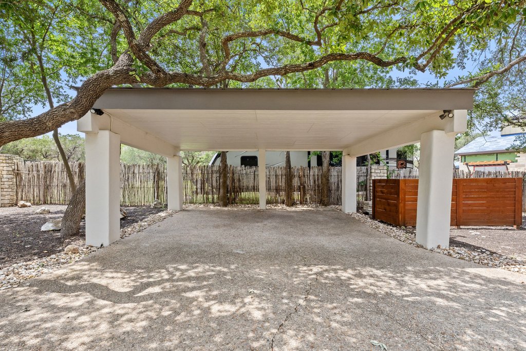 716 North Commons Ford Road Austin, TX 78733 - Photo 28 of 30 Carport structure featuring a concrete slab, white support columns, recessed lighting, and a dark brown overhead trim