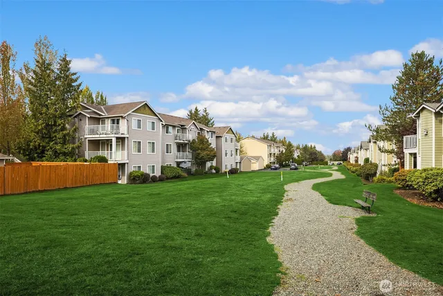 a view of a house with a big yard and large trees