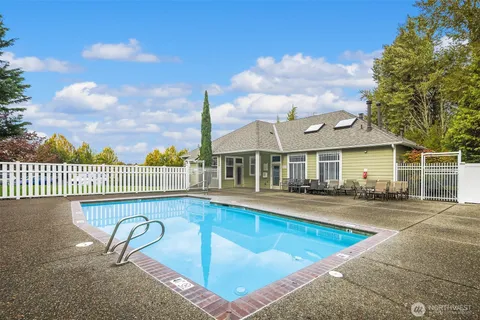 a front view of a house with swimming pool and sitting area