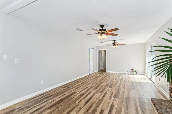 a view of room with a ceiling fan and wooden floor