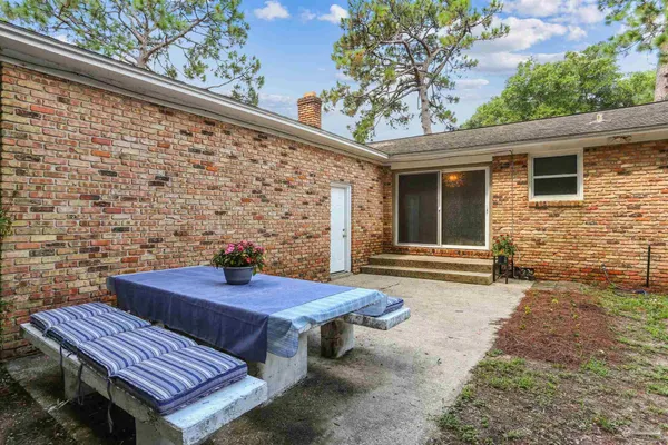 a backyard of a house with barbeque oven table and chairs