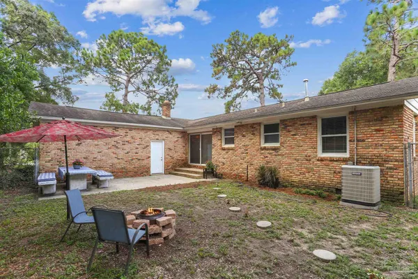 a backyard of a house with barbeque oven table and chairs