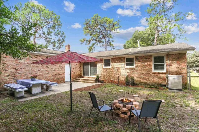 a view of a backyard with table and chairs under an umbrella