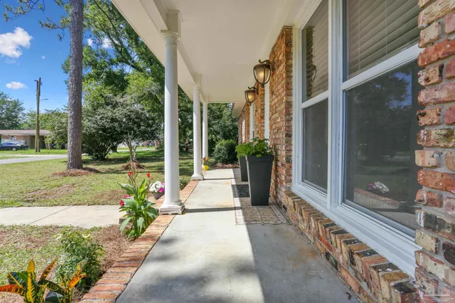 a view of a house with a porch and garden
