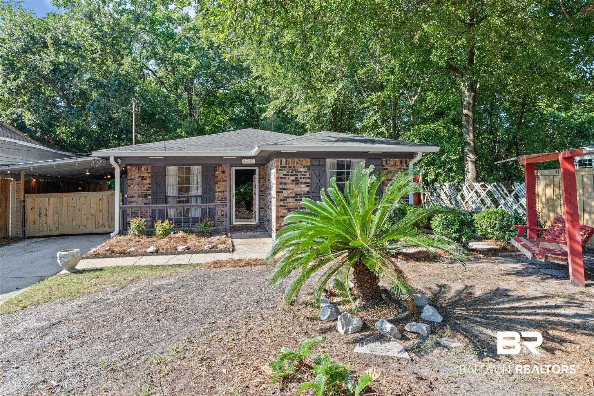 1211 Alba Street Mobile, AL 36605 - Photo 20 of 22 View of front of home with brick siding, driveway, view of wooded area, and a carport