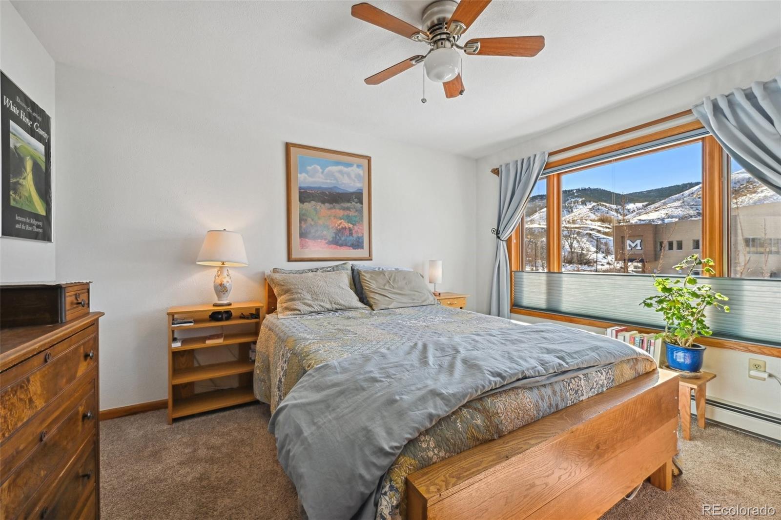 1112 Maple Street Golden, CO 80401 - Photo 13 of 36 a bedroom with a bed and a chandelier
