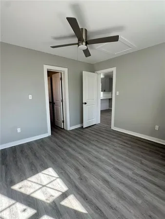 a view of a livingroom with wooden floor and a ceiling fan