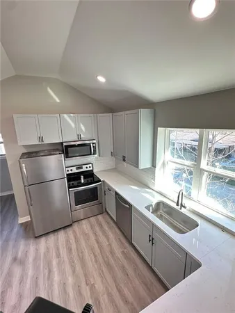 a kitchen with stainless steel appliances a sink a stove a refrigerator and cabinets