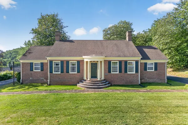 a front view of a house with a garden and yard