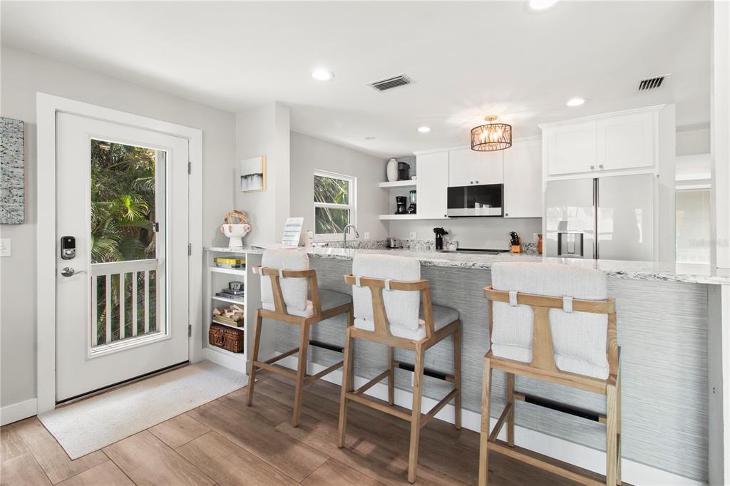 403 North Bay Boulevard Anna Maria, FL 34216 - Photo 13 of 58 a kitchen with stainless steel appliances kitchen island granite countertop a table chairs sink and cabinets
