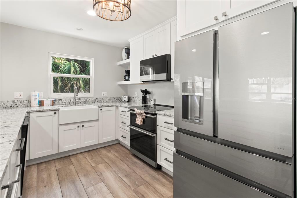403 North Bay Boulevard Anna Maria, FL 34216 - Photo 18 of 58 a kitchen with white cabinets and stainless steel appliances