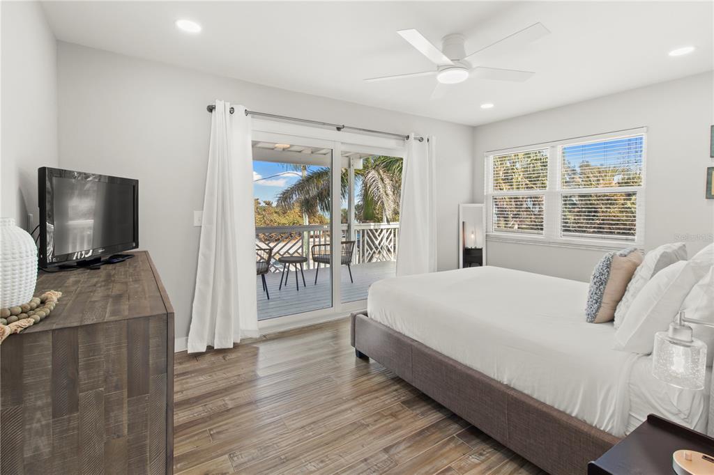 403 North Bay Boulevard Anna Maria, FL 34216 - Photo 30 of 58 a bedroom with a bed and large windows