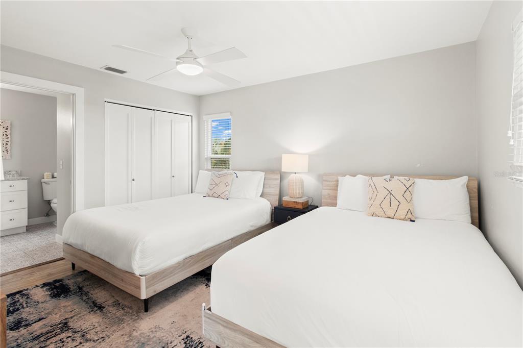 403 North Bay Boulevard Anna Maria, FL 34216 - Photo 38 of 58 a bedroom with two beds and a chandelier