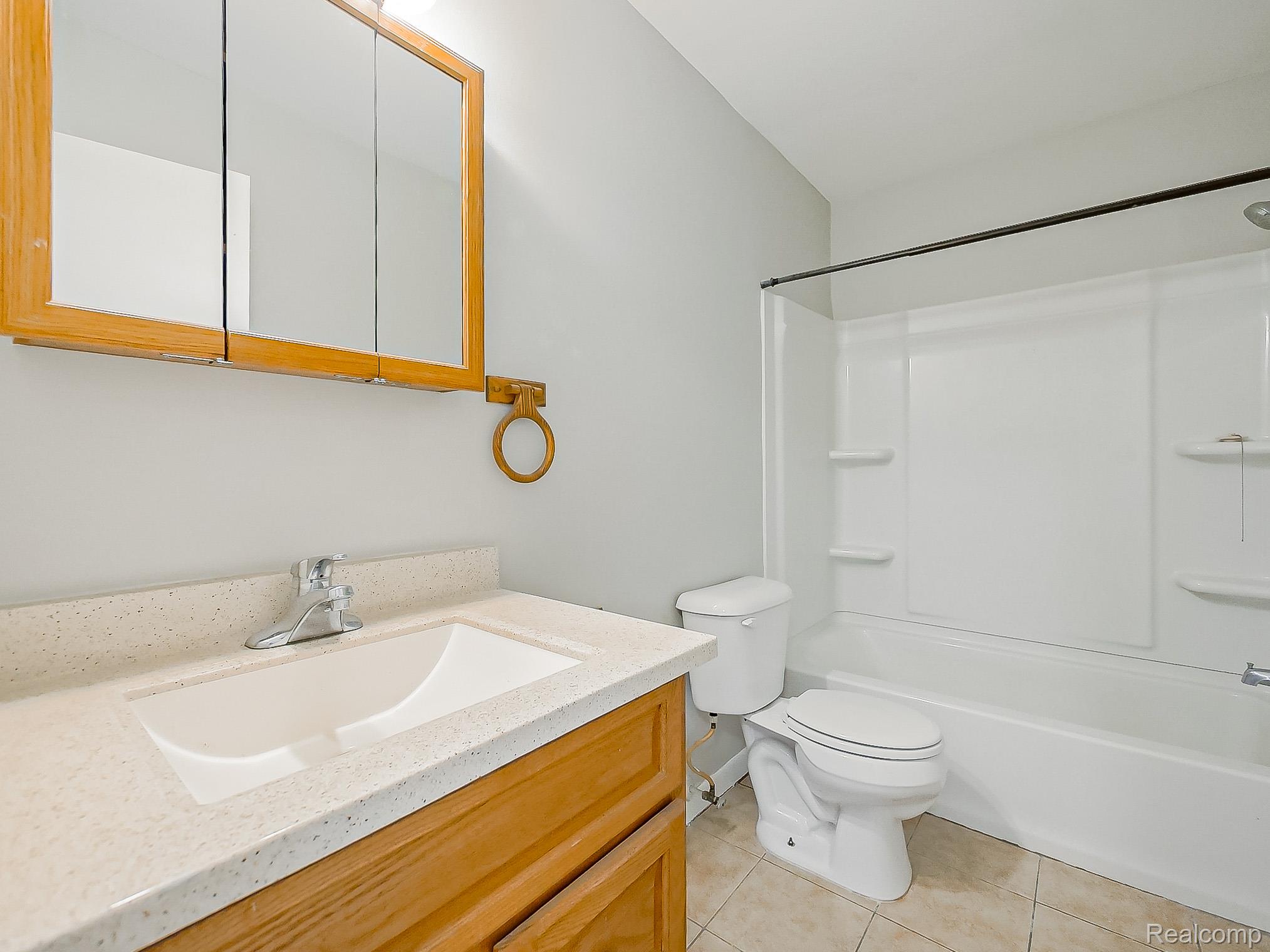 125 East Van Riper Road, Unit 5 Fowlerville, MI 48836 - Photo 20 of 23 Full bathroom with vanity, shower combination, and light tile patterned floors